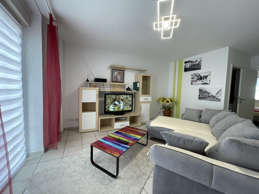 Startseite Wohnzimmer mit Eckcouch und bodentiefem Fenster