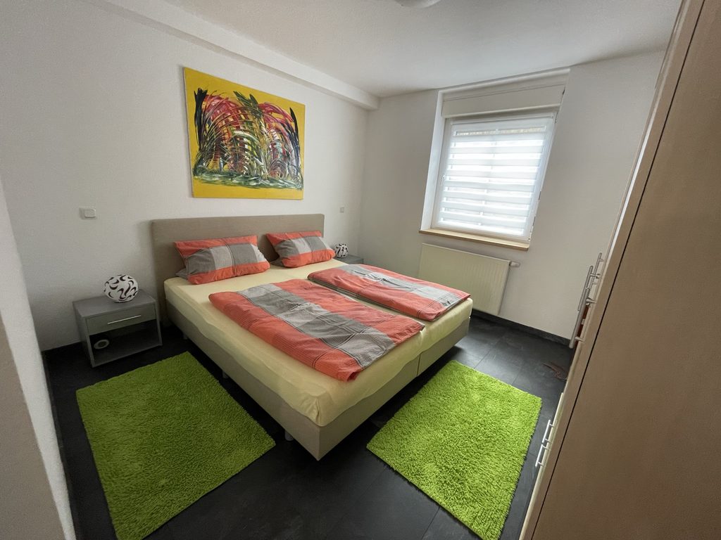 Startseite Schlafzimmer mit Doppelbett und farbigen Akzenten